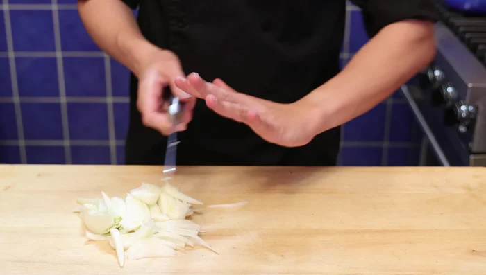 Couper l'oignon et le poivron en tranches de taille égale. Utiliser une technique de découpe efficace (mentionnée dans la vidéo).