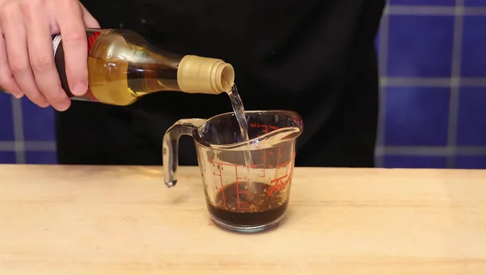 Préparer la sauce: mélanger la sauce soja, la sauce soja foncée, le sucre de canne, les épices, le vinaigre de riz, l'ail et la sauce au piment doux.