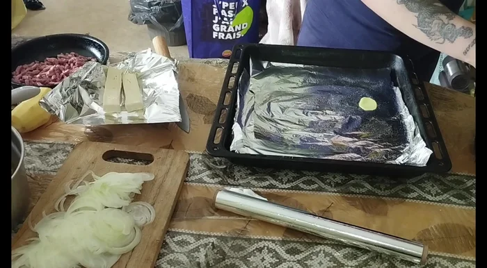 Dans un plat allant au four, disposer une couche de pommes de terre précuites, puis l'oignon, les lardons et un peu de sauce. Répéter l'opération pour une deuxième couche.