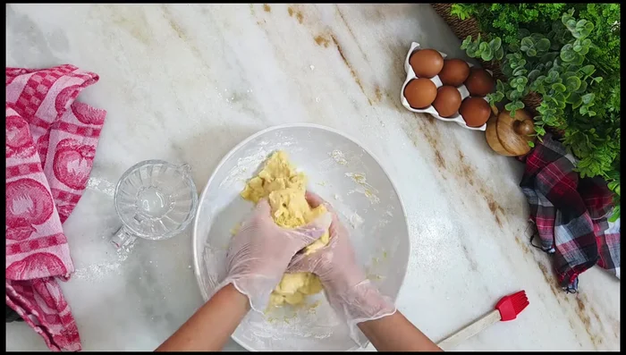 Pétrir la pâte à la main (avec des gants) jusqu'à obtenir une pâte lisse et élastique. Ajouter progressivement l'eau si nécessaire.