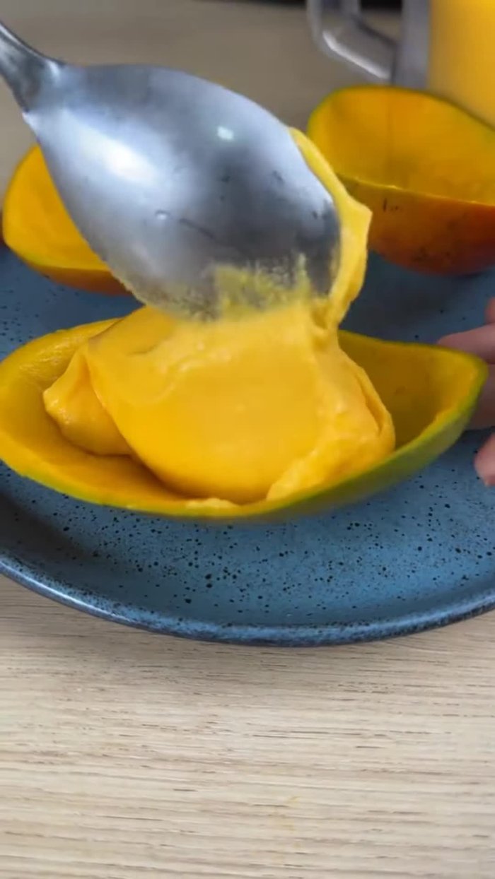 Couper les mangues en deux. Faire des entailles dans la chair pour faciliter l'extraction. Retirer la chair en petits morceaux, en laissant la peau intacte.