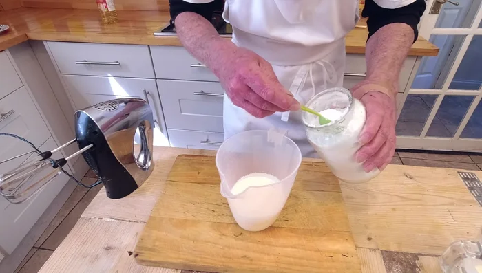 Préparer la crème pâtissière en fouettant la crème double, le sucre glace et l'extrait de vanille jusqu'à consistance ferme. (455.52)