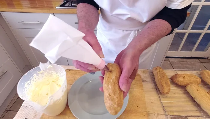 Remplir les éclairs de crème pâtissière à l'aide d'une poche à douille. (661.44)
