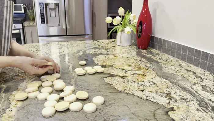 Glacer les macarons avec le glaçage maracuja et le glaçage café.