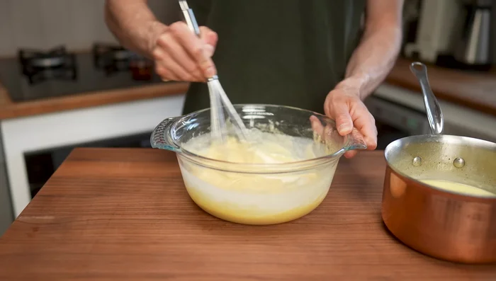 Incorporer progressivement le lait tiédi à la pâte. Ajouter le rhum et la gousse de vanille. (198.44)