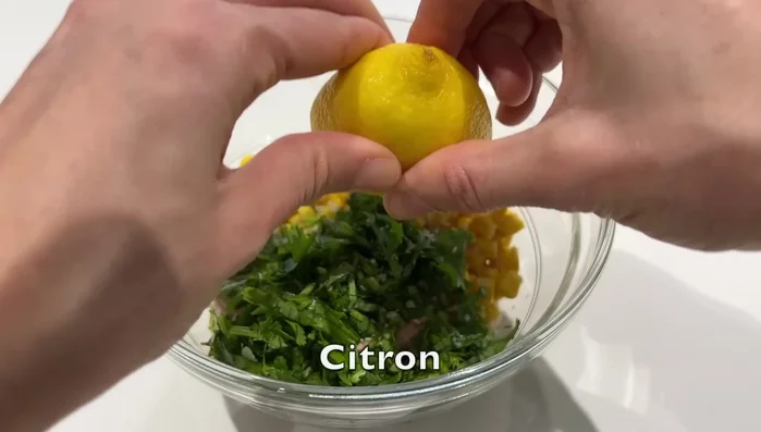 Préparation de la garniture au thon : Mélanger du thon, du maïs, de la coriandre, du citron, du sel, du poivre, de l'huile d'olive et de la mayonnaise.