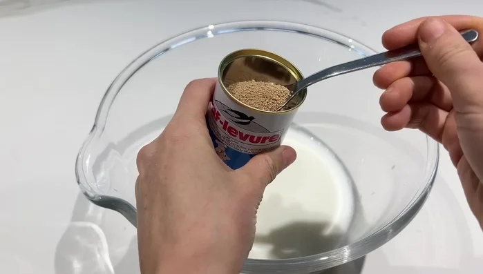 Préparation du pain rapide : Mélanger 20cl de lait tiède, 10cl d'eau tiède, une cuillère à soupe de sucre et une cuillère à café de levure.