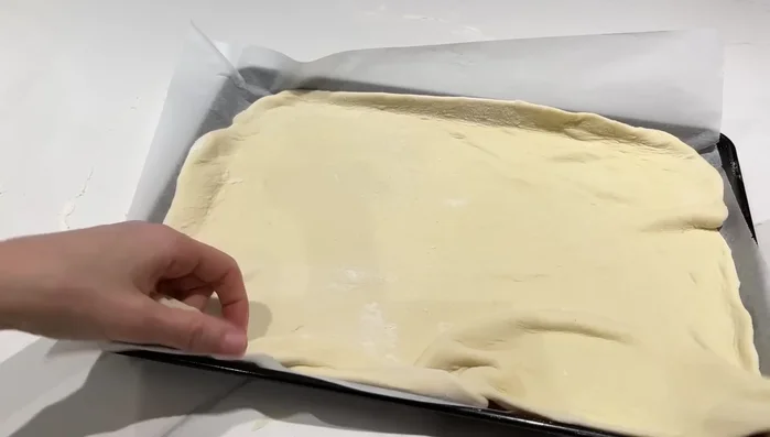 Étaler la pâte, ajouter de la sauce tomate/crème, la farce et du fromage. Recouvrir avec la deuxième pâte.