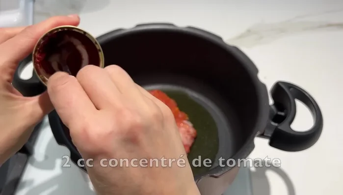 Préparation de la soupe : Faire revenir de l'huile d'olive, de la viande, des tomates, un demi-oignon, du concentré de tomates, des pois chiches, du céleri, de la coriandre, du gingembre, du curcuma, du sel et du poivre.