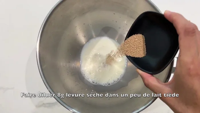 Préparer la pâte à brioche : Diluer la levure sèche dans du lait tiède.