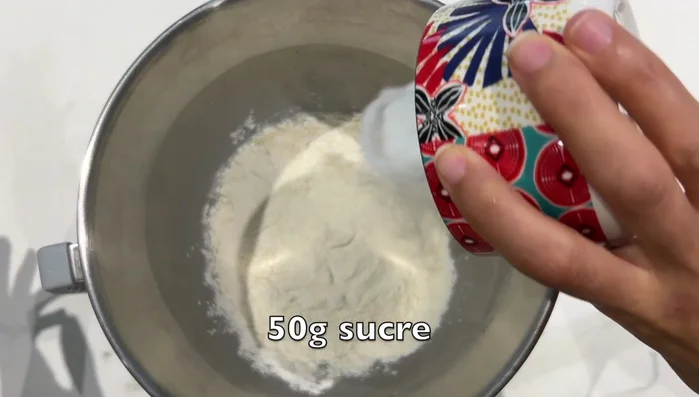 Ajouter la farine, le sucre, le sel, le jaune d'œuf et le reste du lait tiède. Bien pétrir pendant 10 minutes.