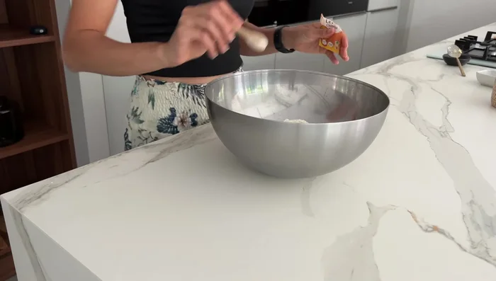 Préparer la pâte sablée en mélangeant le beurre mou, l'œuf, la levure chimique, le sucre et la farine. Travailler la pâte sur le plan de travail pour obtenir une texture sablée.