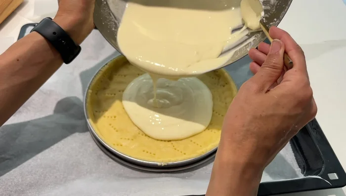Verser la crème sur la pâte, ajouter les fruits et les amandes effilées.