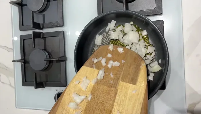 Faire revenir l'oignon dans une poêle avec un peu d'huile d'olive pendant environ 5 minutes à feu doux/moyen.