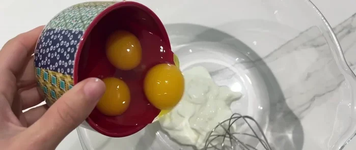 Dans un saladier, mélanger le yaourt, les œufs, le sucre, les amandes en poudre, la farine, la levure chimique, le bicarbonate, la cannelle et le sel.