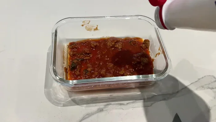 Montage des lasagnes : Alterner les couches de lasagnes, de sauce tomate, de crème fraîche liquide et de fromage. Placer dans des contenants individuels.