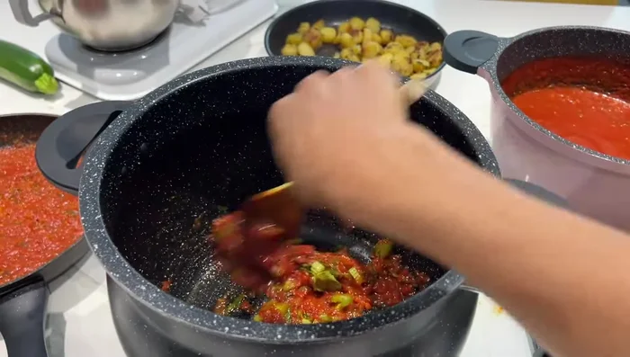 Préparation du couscous : Faire revenir des tomates, du concentré de tomates, du persil, de la coriandre et du céleri. Ajouter 600g de couscous fin, de l'huile d'olive et de l'eau tiède. Bien mélanger et laisser absorber l'eau. Ajouter des légumes (carottes, navets, courgettes, céleri).