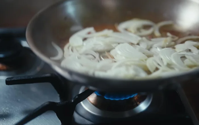 Ajouter les poivrons et les champignons, poursuivre la cuisson. (Musique de fond)