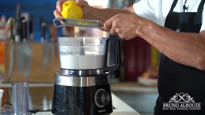 Préparez la pâte : Mélangez la farine, le sucre, la poudre d'amande et le sel. Ajoutez le zeste de citron et le beurre froid en cubes. Travaillez la pâte rapidement (environ 20 secondes).