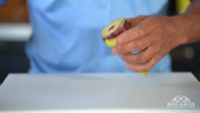 Coupez les deux tiers du haut de l'artichaut, frottez avec du citron et enlevez la partie duveteuse (le foin) à l'aide d'un couteau ou d'un outil spécial.