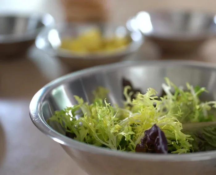 Dresser la salade : Dans un grand bol, napper de vinaigrette. Ajouter les légumes verts, puis ajouter de la vinaigrette supplémentaire. Mélanger délicatement.