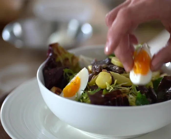 Garnir et servir : Garnir de pignons de pin grillés, croûtons, œufs et plus de vinaigrette.