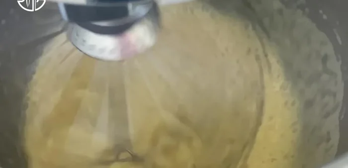 Ajouter le beurre à la crème anglaise refroidie, à basse vitesse puis à grande vitesse jusqu'à obtenir une texture lisse. Préparer la meringue italienne : Battre les blancs d'œufs à vitesse moyenne. Cuire le sucre à 121°C (250°F) et verser lentement le sirop chaud sur les blancs d'œufs en battant à haute vitesse pendant environ 5 minutes.