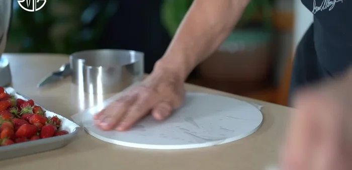 Montage du gâteau : Construire le gâteau à l'envers sur une plaque plate, légèrement graissée et recouverte d'acétate de plastique. Placer les fraises, ajouter la garniture (crème pâtissière, crème au beurre, meringue italienne), lisser. Ajouter la marmelade de fraises et recouvrir de garniture.