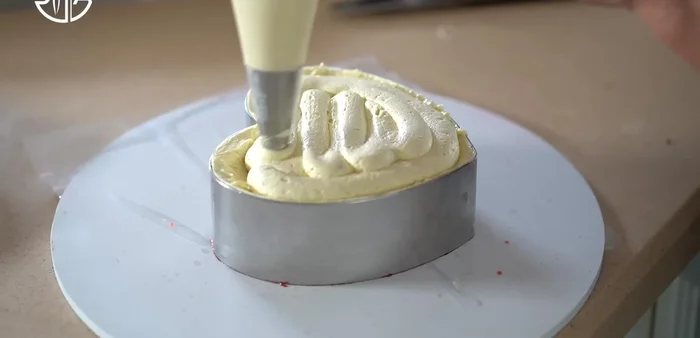 Tremper le biscuit aux amandes dans le cocktail de framboises. Retourner le gâteau, laisser reposer et refroidir au moins 5 heures avant de démouler.