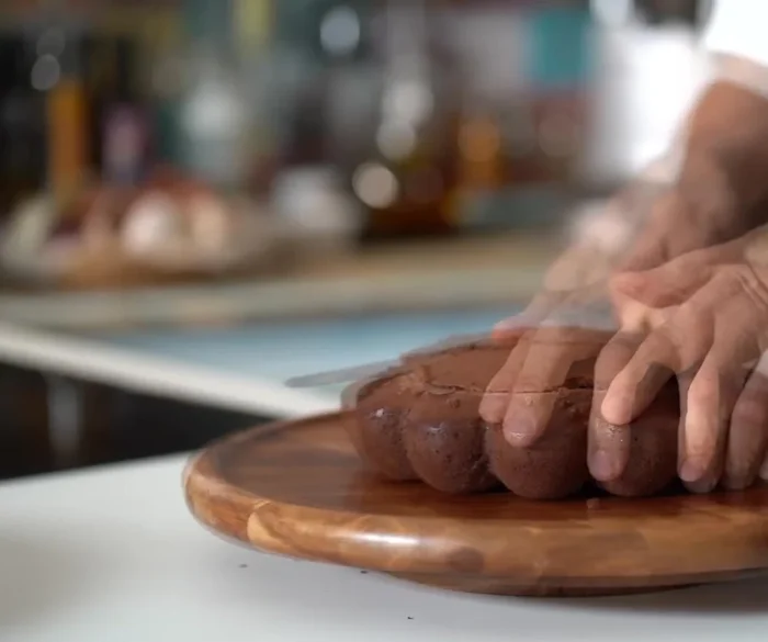 Démouler le gâteau en coupant le dessus, le retourner et l'hydrater avec un sirop simple aromatisé (rhum, Gramman...) ou de l'eau de fleur d'oranger et de l'extrait de vanille.