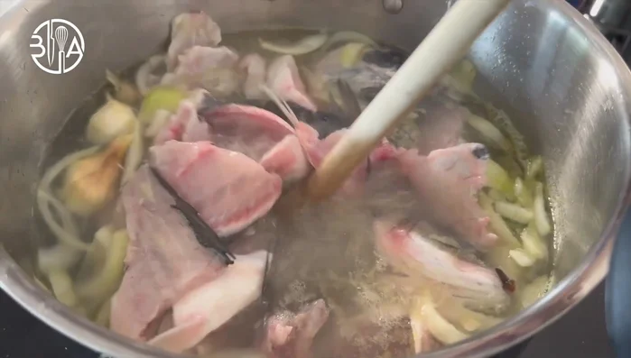 Préparer un fumet de poisson : Faire mijoter les arêtes et têtes de poisson avec les légumes aromatiques (oignons, ail, fenouil, poireau, Bou Garney) dans un bouillon d'eau et de vin blanc pendant 25 minutes. Égoutter et réserver le bouillon.