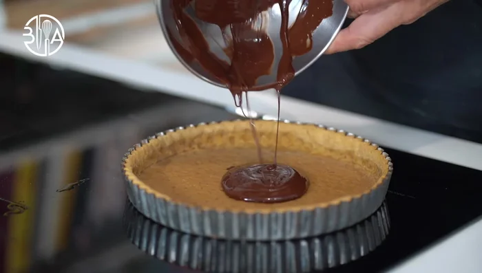 Étaler le chocolat noir fondu et garnir de pois.