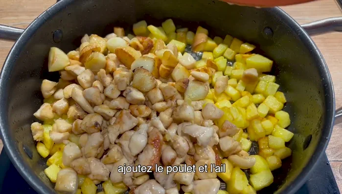Ajoutez le poulet et l'ail dans la poêle. Poursuivez la cuisson en ajoutant de la sauce soja et de la sauce huître.
