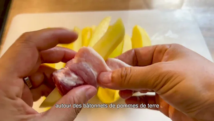 Enrouler les tranches de porc autour des bâtonnets de pommes de terre et les fixer avec des cure-dents.