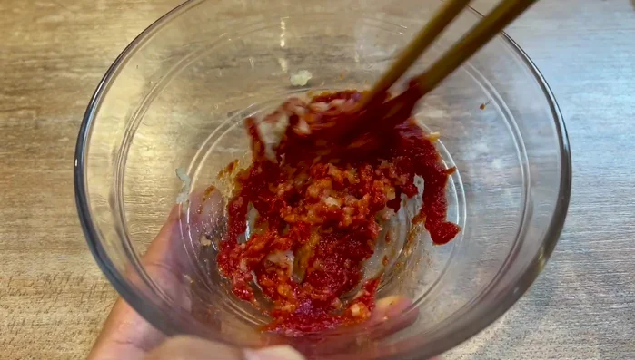 Préparez la sauce en mélangeant l'ail haché, la sauce tomate concentrée, le piment d'Espelette, les graines de sésame, le jaune d'œuf, le poireau, l'huile chaude, la sauce huître, le sucre, la coriandre, la poudre barbecue et la sauce soja claire.