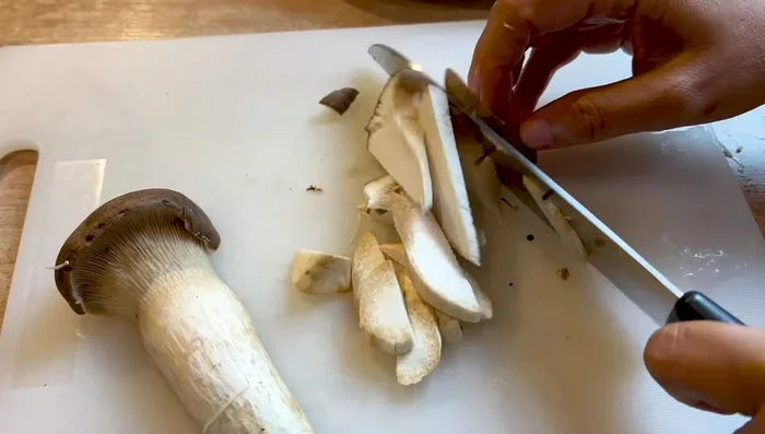Préparer tous les ingrédients: nettoyer et émincer légèrement les champignons à l'eau chaude.