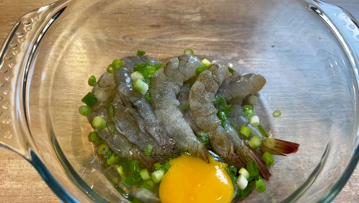 Mélanger les crevettes avec la ciboulette, un œuf, du sel, de l'amidon et de la farine de poulet.