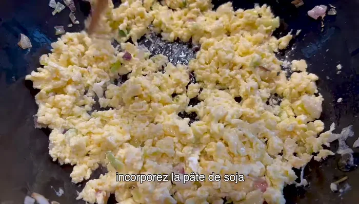 Lorsque les œufs sont cuits, incorporez la pâte de soja et continuez la cuisson à feu doux.