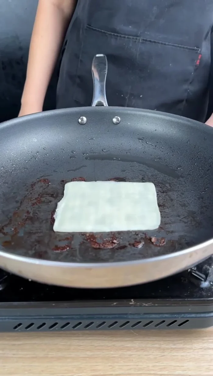 Faire fondre des tranches de fromage dans la même poêle.