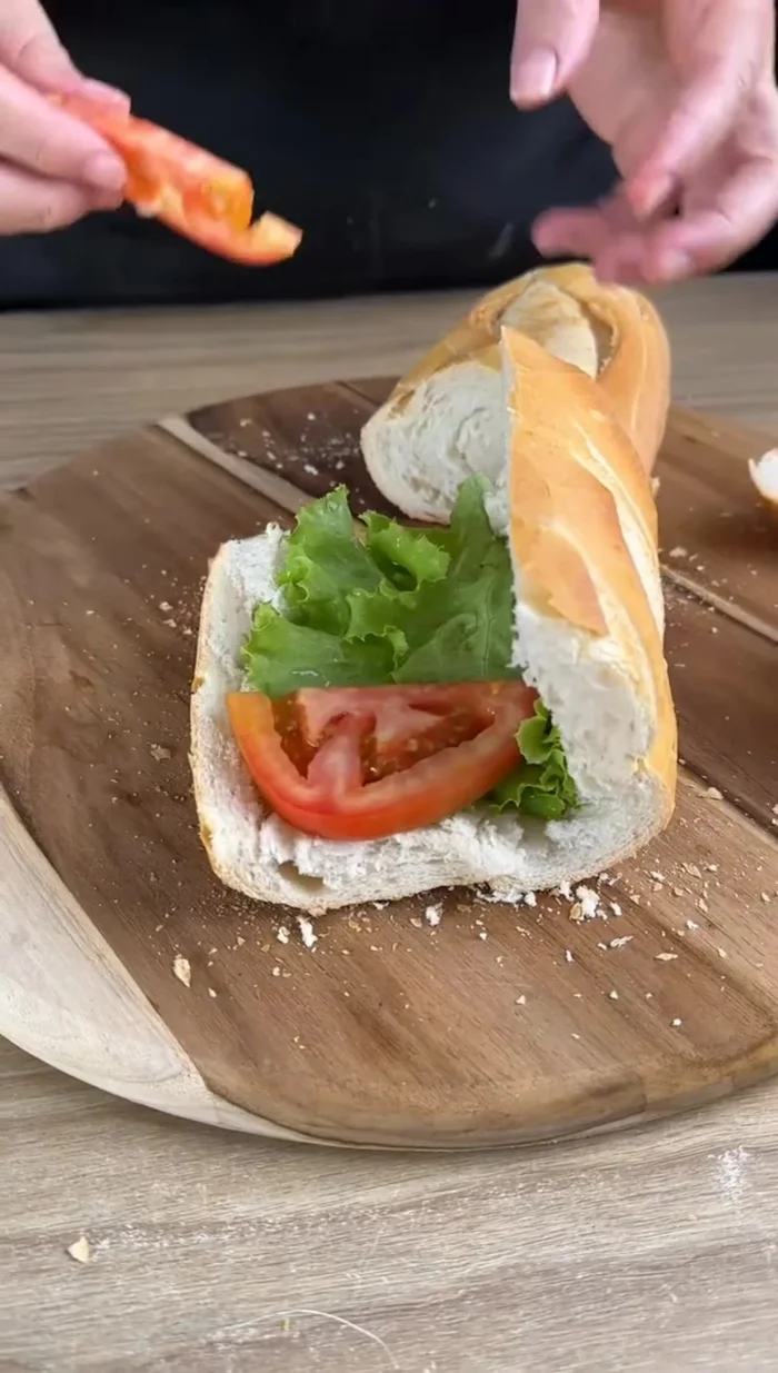 Garnir le pain avec de la laitue, des tomates, les brochettes au fromage, de l'oignon haché, du ketchup, de la mayonnaise et de la moutarde.