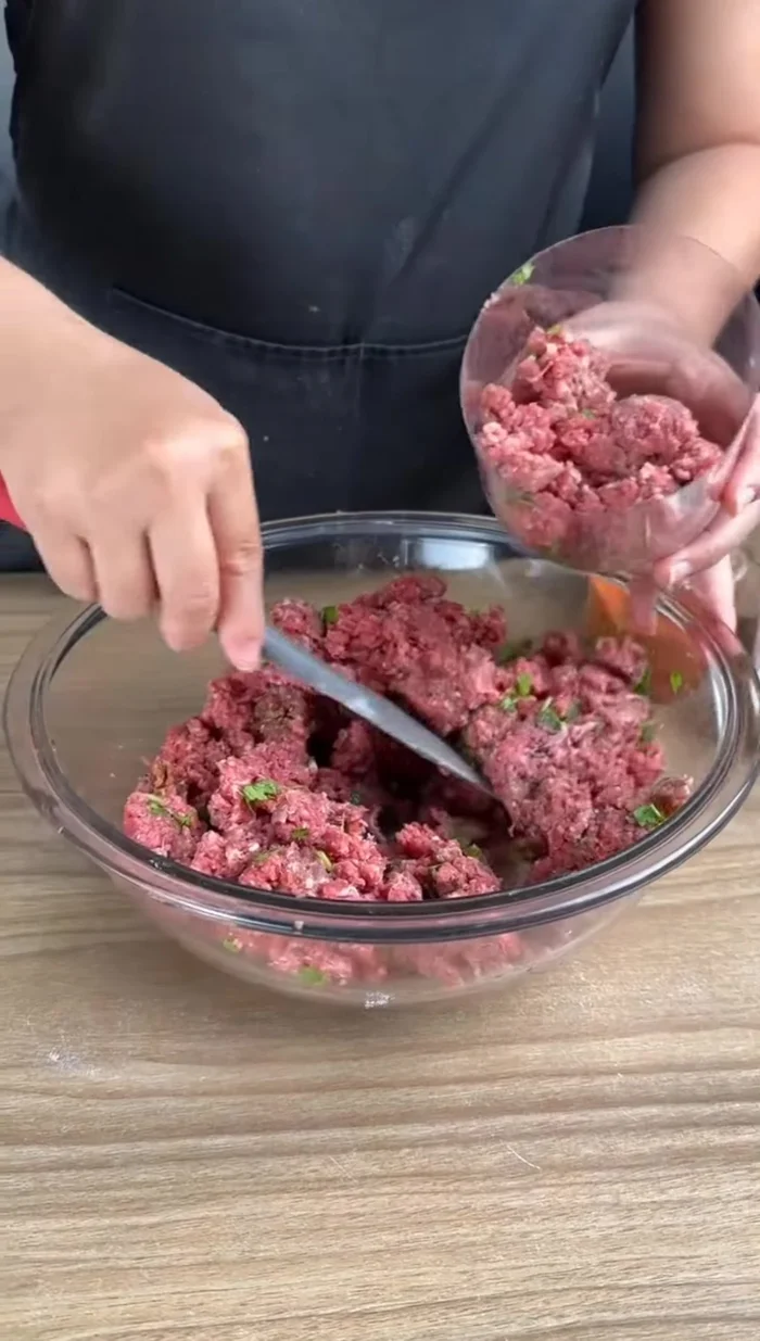 Remplir une bouteille en plastique coupée en deux avec la viande hachée, en tassant bien.