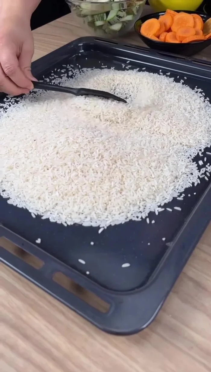 Étaler le riz dans un plat de cuisson, ajouter les carottes, courgettes et poivron rouge coupés en tranches.