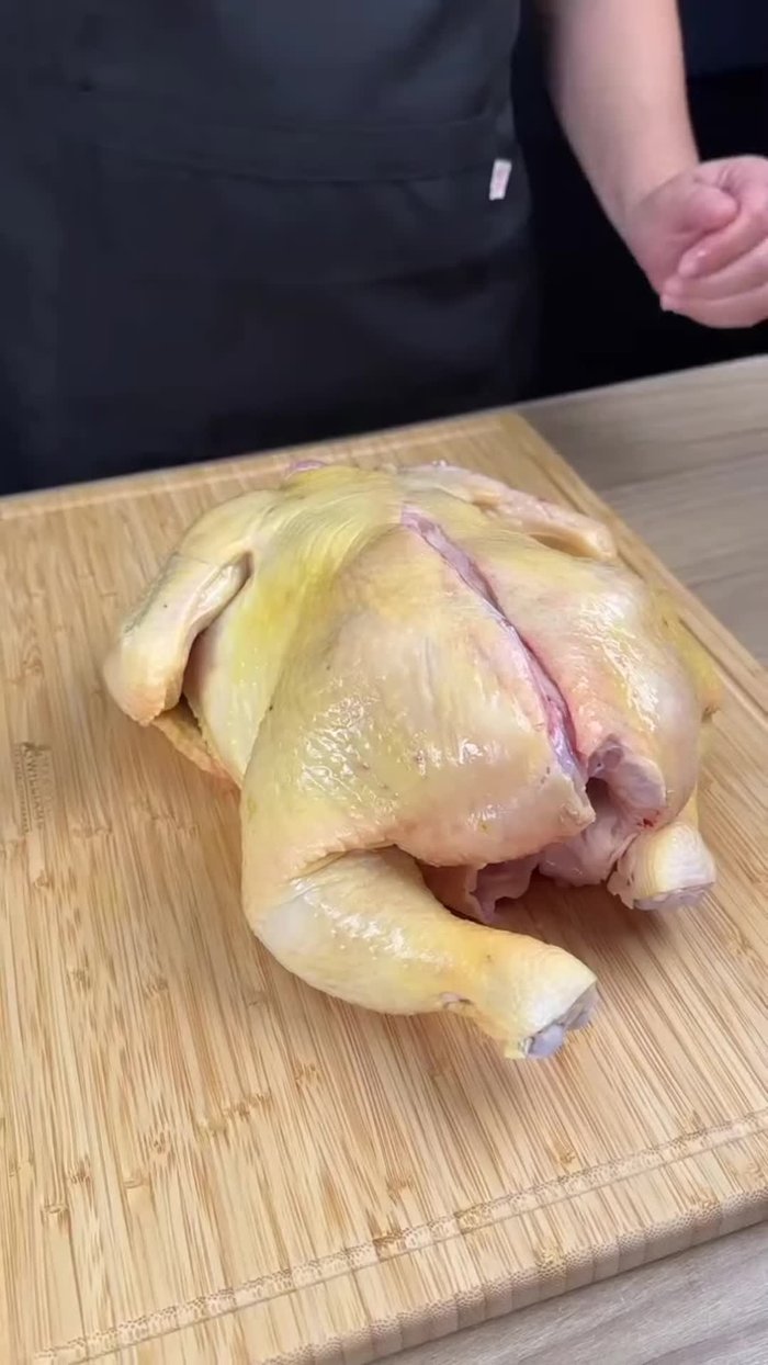 Séparer le poulet entier, couper les ailes et couper le poulet en deux.