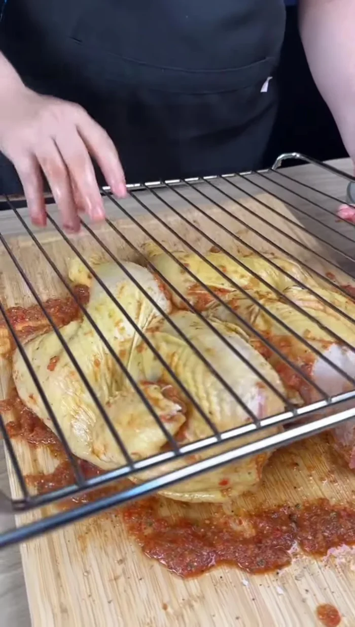 Percer le poulet avec des brochettes pour maintenir les morceaux ensemble et le placer sur une grille.