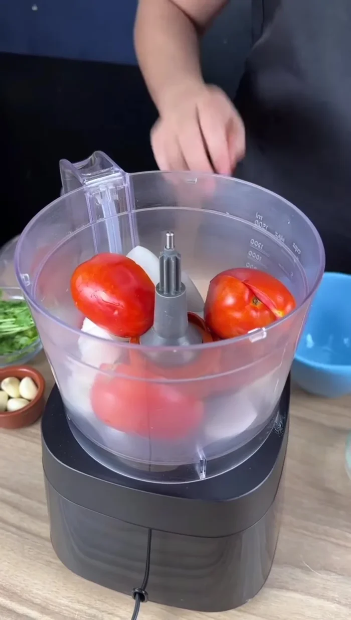 Mixer l'oignon, les tomates, les poivrons jaune et rouge, l'ail et la coriandre fraîche.