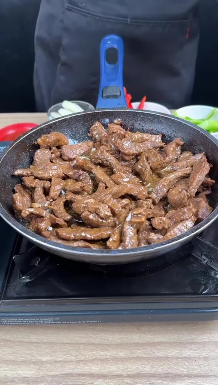 Ajoutez les poivrons (jaune, vert, rouge) et l'oignon coupé en tranches à la viande. (140.12)