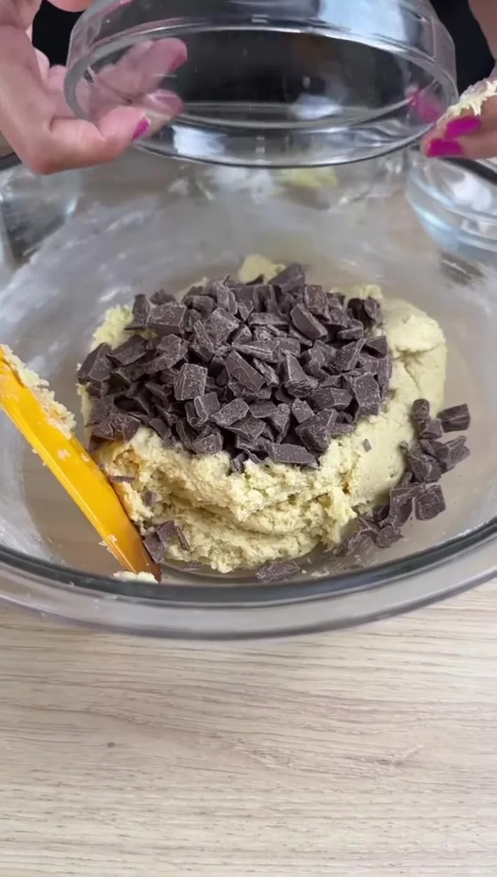 Ajouter l'extrait de vanille (1 cuillère à café) et le chocolat haché (100g). Mélanger jusqu'à obtenir une pâte homogène.