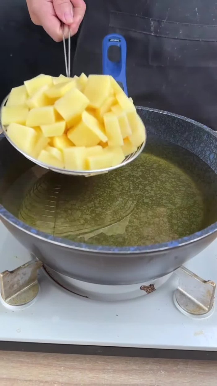 Coupez 4 pommes de terre en dés et faites-les frire dans une poêle avec de l'huile jusqu'à ce qu'elles commencent à dorer.