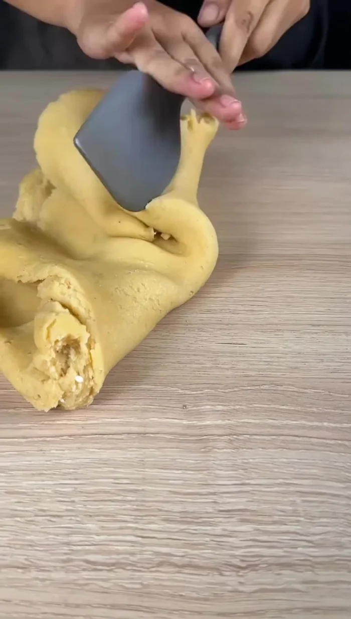 Transférer la pâte sur une surface propre et continuer à la travailler avec une spatule en l'ouvrant et la repliant pour la refroidir.