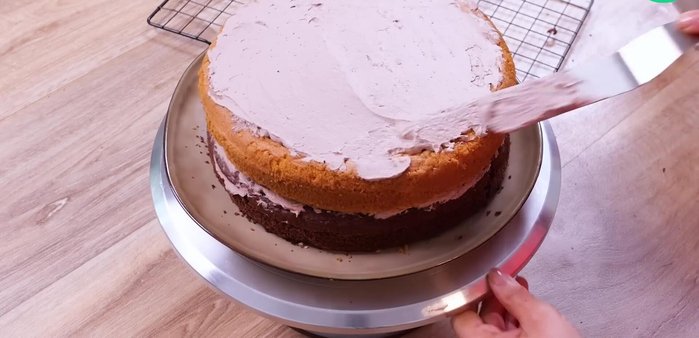 Badigeonner complètement le gâteau avec le reste de chantilly au chocolat et lisser.